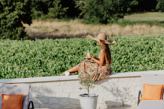 Présentation des produits Anthèse par une jeune fille à chapeau face aux vignes