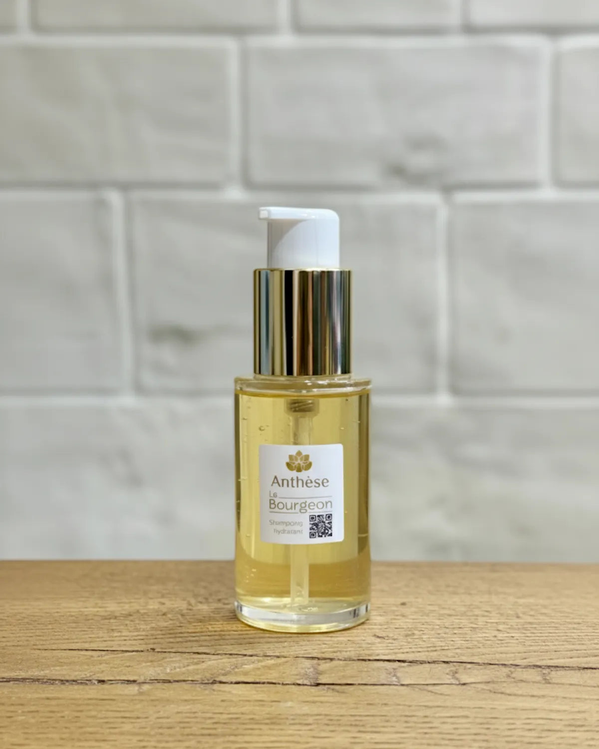 Shampoing Le Bourgeon 50 ml posé sur un plan de travail avec carrelage blanc, soin pour cheveux naturels.